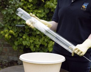 Hanging tube feeder for garden birds being cleaned